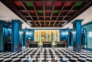 Un vestíbulo con piso a cuadros, paredes azules y techo con luces de colores.