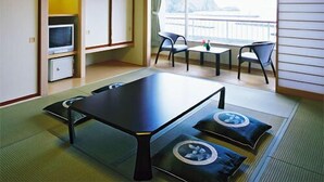 A room with tatami flooring, a low table, chairs, a television, and a view of a body of water. - Izumatsuzaki Sou (Matsuzaki)