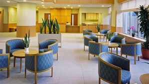 A spacious lobby with a high ceiling, multiple seating areas, and a reception desk. - Izumatsuzaki Sou (Matsuzaki)