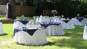 Des tables rondes ont été installées à l’extérieur, recouvertes de nappes blanches et bleu marine, et disposées en rangées.