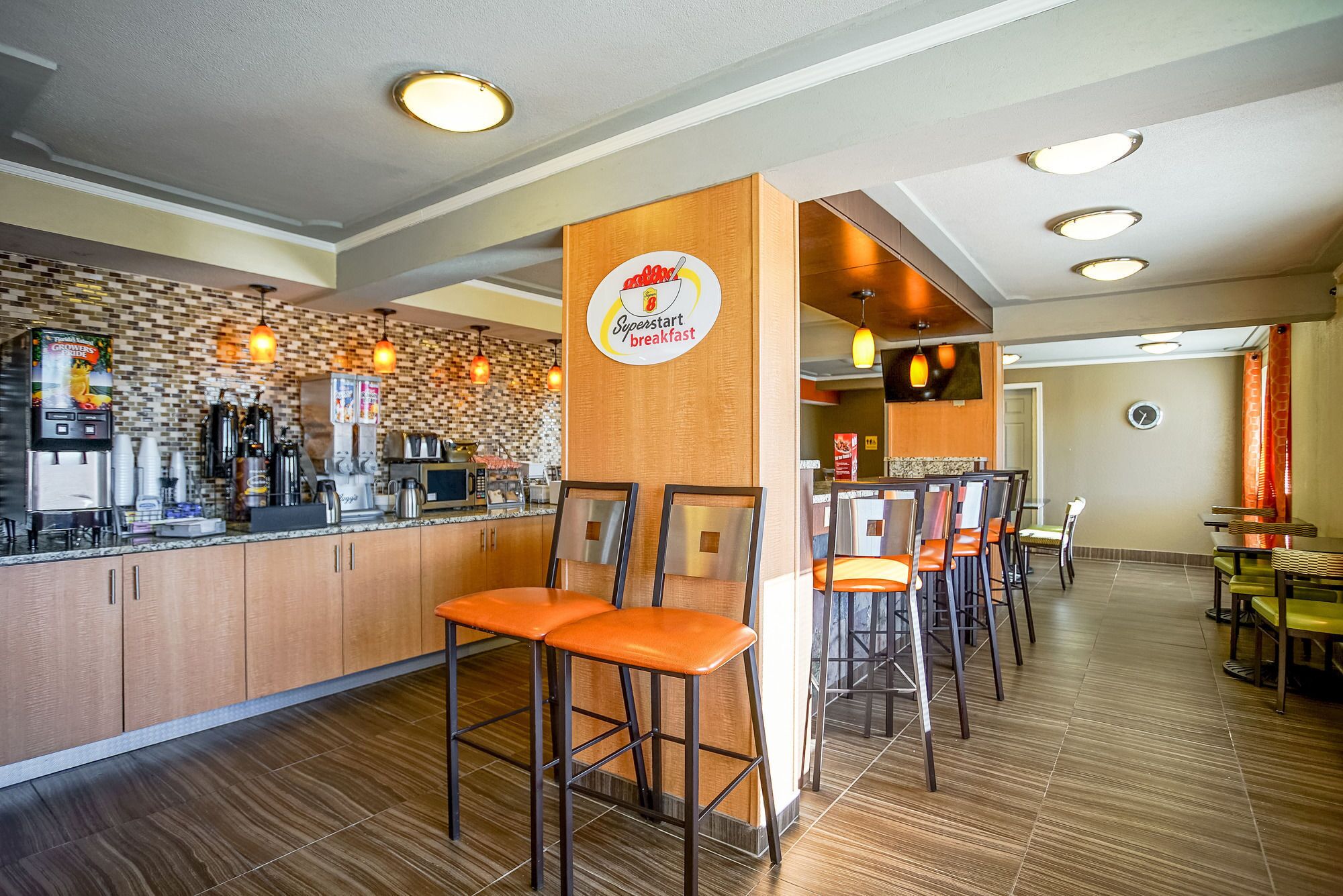A breakfast area with a counter, coffee machines, and seating.