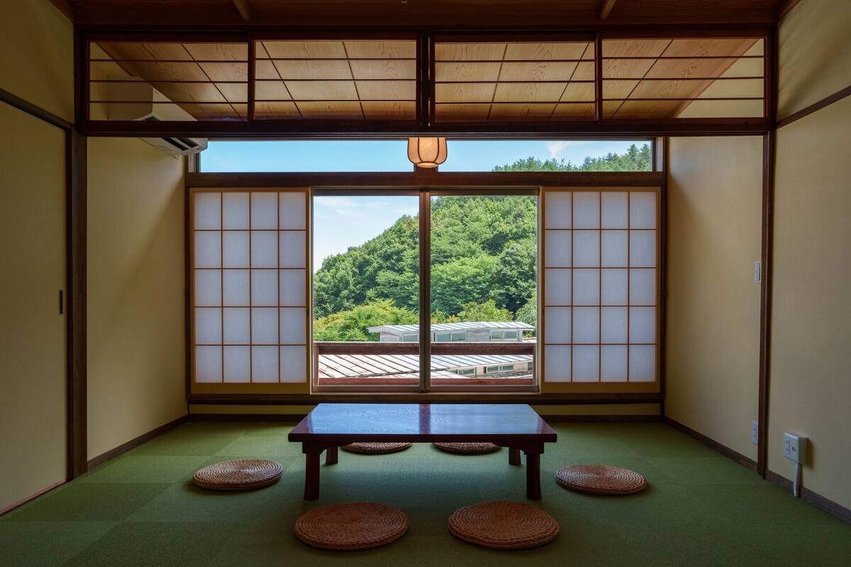 A traditional Japanese room with tatami flooring, a low table, and shoji screens.