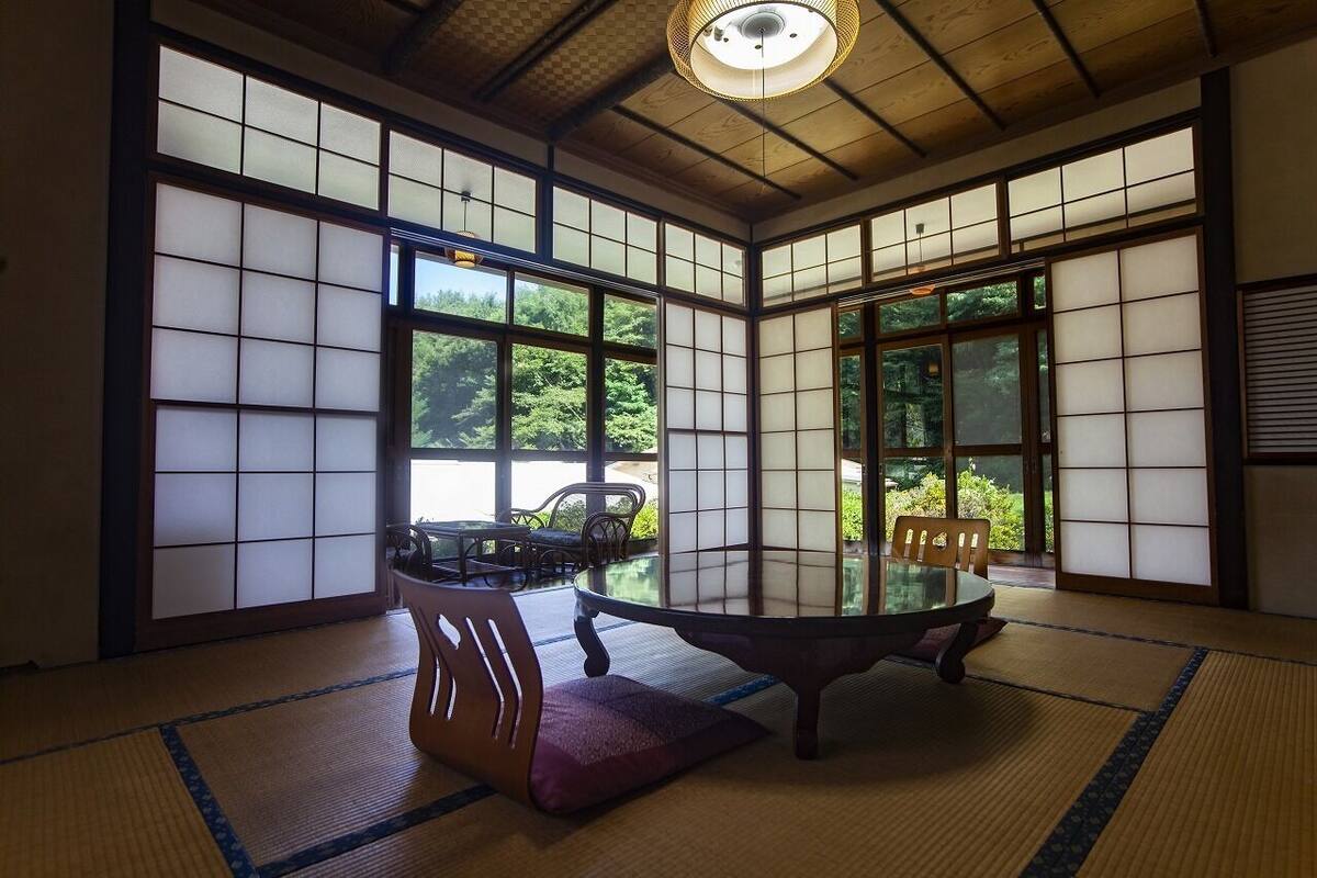 A traditional Japanese room with tatami flooring, a low table, and sliding doors.