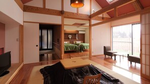 A traditional Japanese-style room with tatami flooring, a low wooden ceiling, and sliding doors. - Takanosho (Aso)