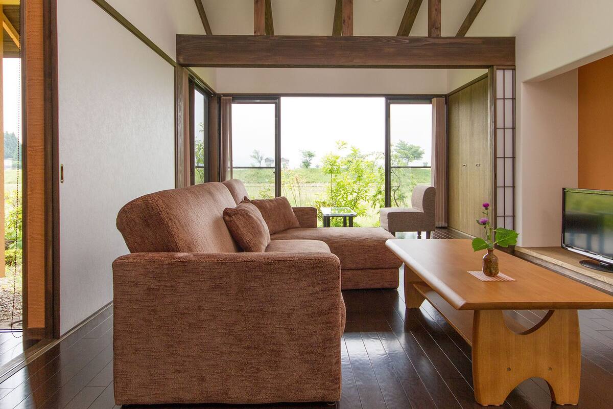 Una sala moderna con sofá, mesa de centro y televisor.