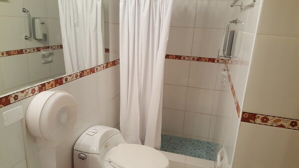 A bathroom with a toilet, a shower, and a hand dryer. - Suite Service Apart Hotel (Lima)