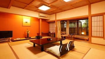Um quarto japonês tradicional com tatames, uma mesa baixa e portas deslizantes.