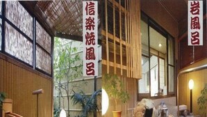 Un onsen japonés tradicional con una bañera de piedra, paredes de madera y detalles de bambú.