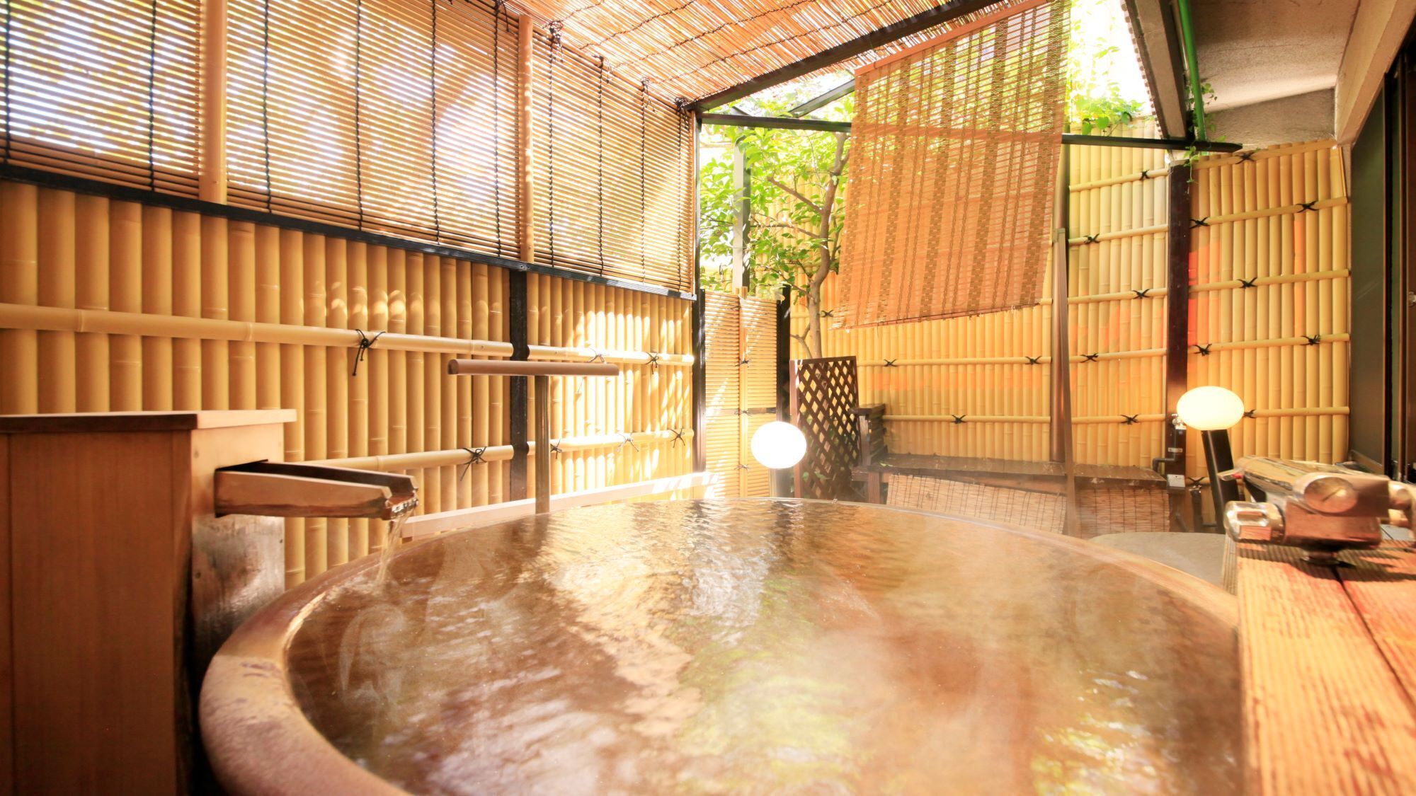 Un onsen japonés tradicional con interior de madera, una piscina de aguas termales y paredes de bambú.