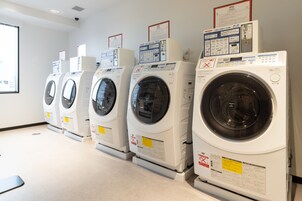 A row of front-loading washing machines in a commercial setting.