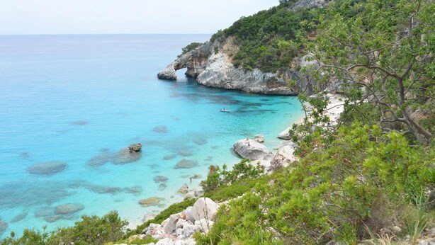 A coastal landscape with clear turquoise waters, rocky cliffs, and dense greenery. - B&B Rita and Family (Loceri)