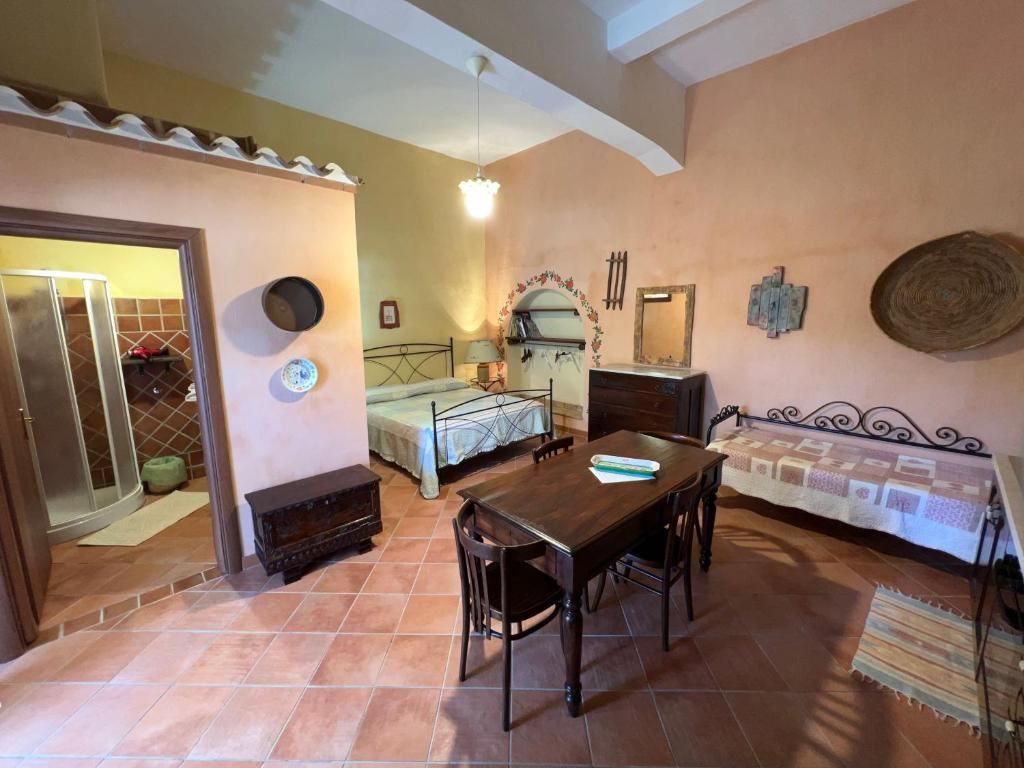 Una habitación con una mesa de comedor, sillas, un sofá, una chimenea y una cama.