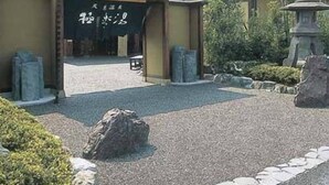 A traditional Japanese building with a tiled roof and a signboard. - Phoenix Hotel (Tsu)