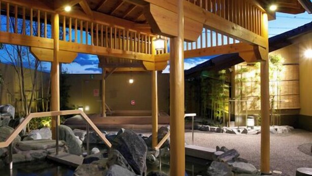 A wooden structure with a stone pathway and a small pond. - Phoenix Hotel (Tsu)