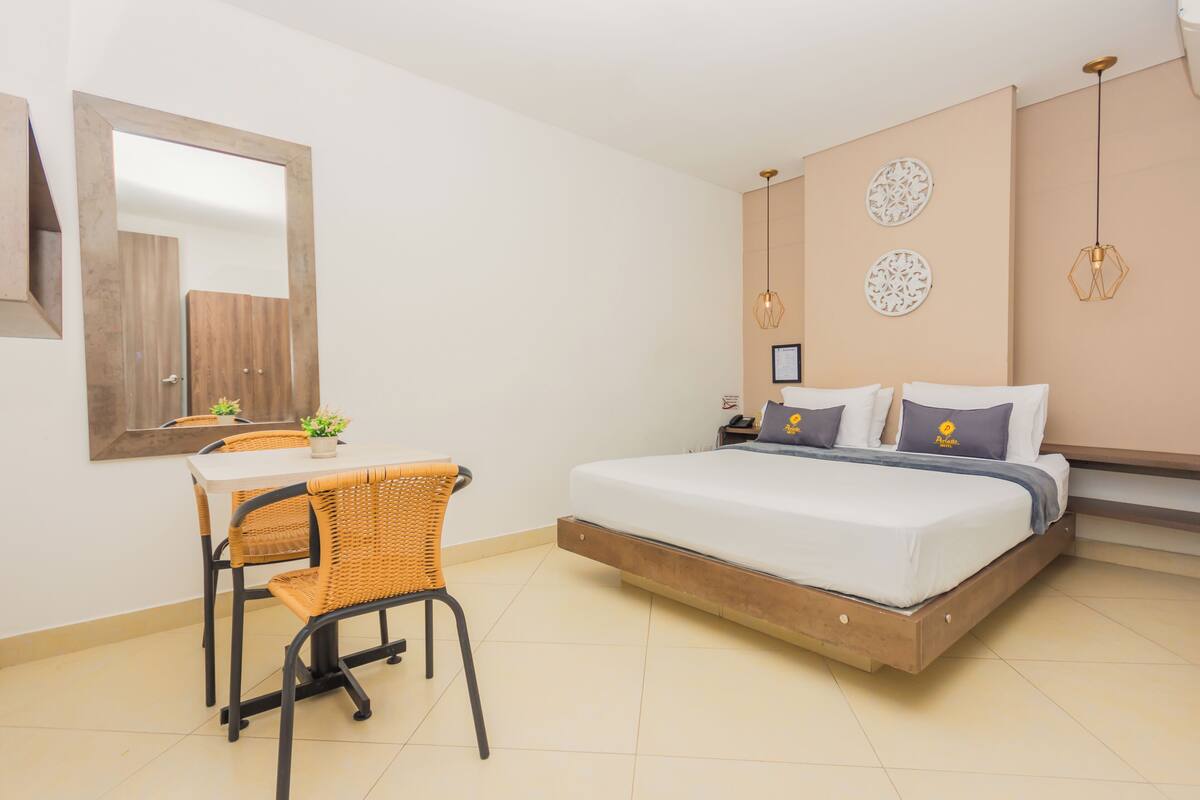 Quarto com uma cama, uma escrivaninha e uma cadeira.