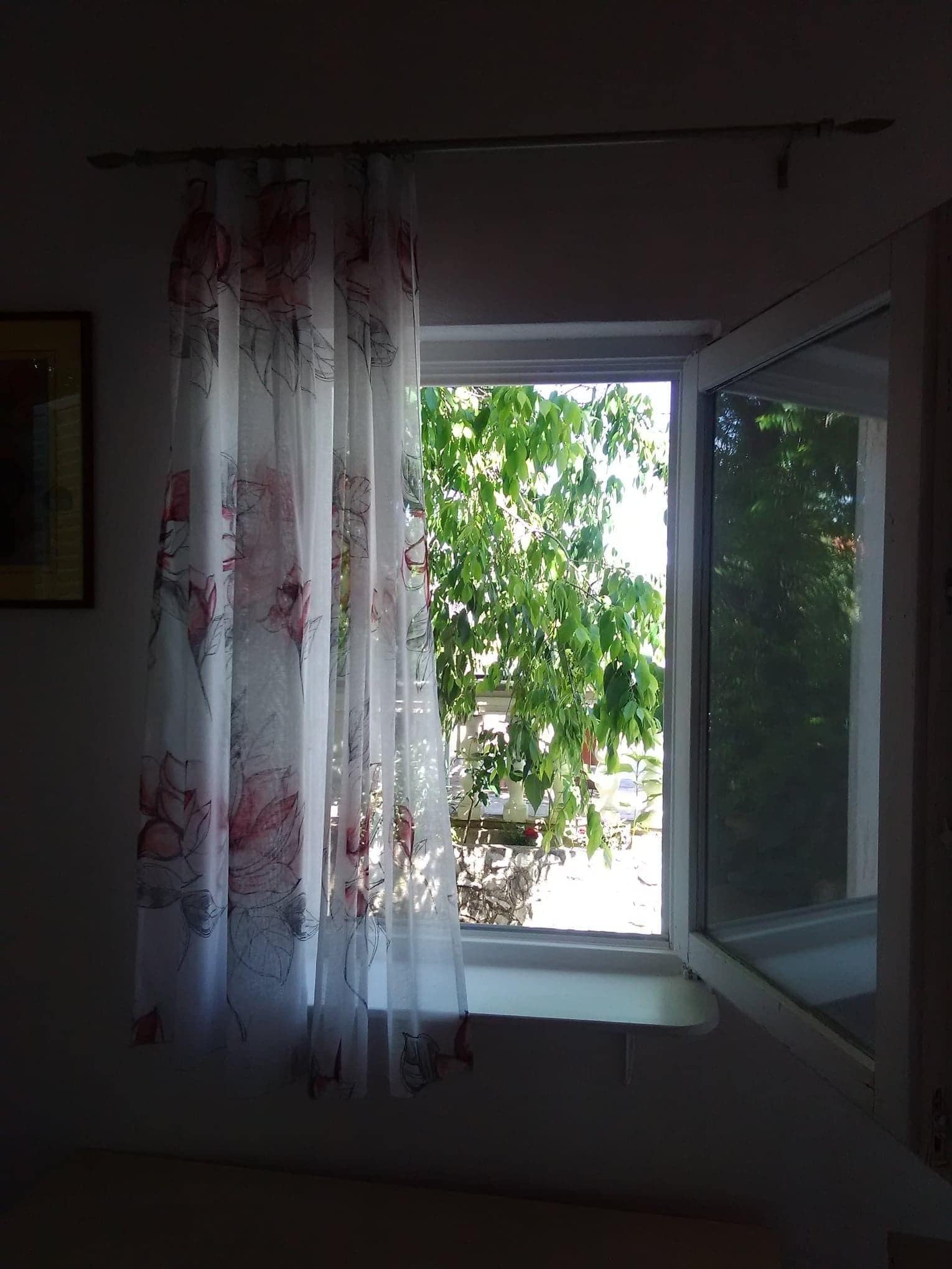 Una habitación con ventana y cortina.