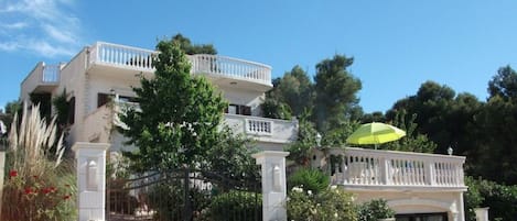 Ein zweistöckiges Gebäude mit Balkon, Steinmauern und einem verschlossenen Eingang.