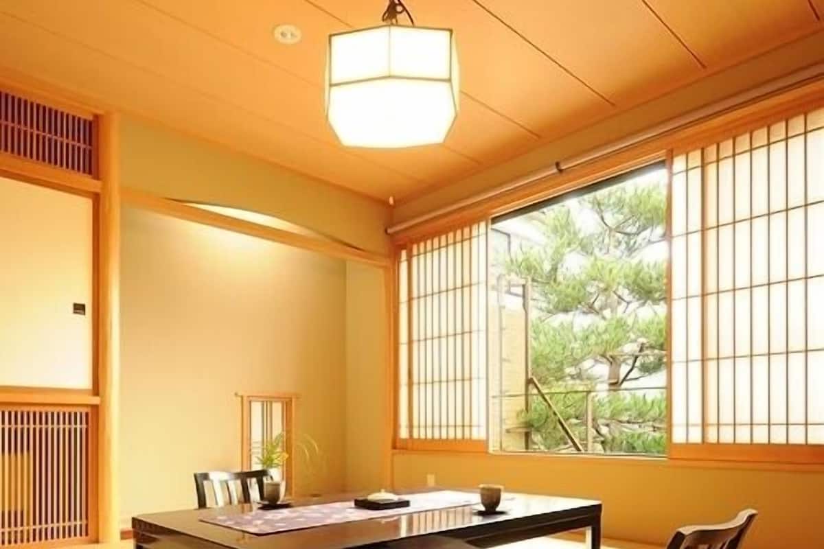 A traditional Japanese room with tatami flooring, a low table, and shoji screens.