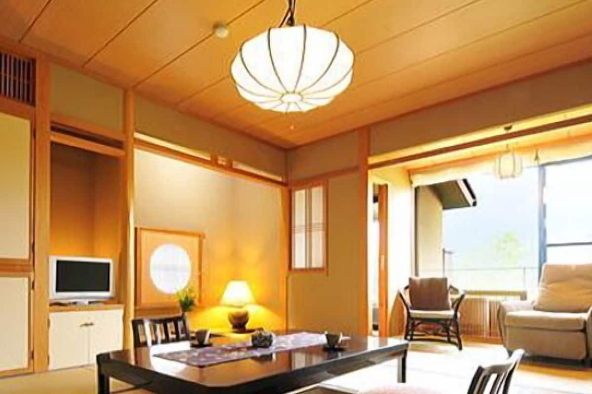 A traditional Japanese-style room with tatami flooring, a low table, and a sofa.