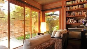 A cozy reading nook with a sofa, chairs, and a bookshelf. - Okutsumagoi Onsen Hanaichi Hoshikawa Ryokan (Tsumagoi)