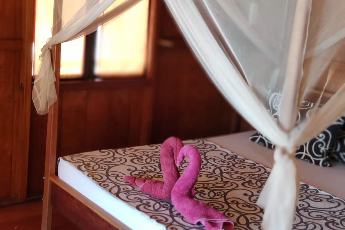 Un lit à baldaquin décoré d’un motif de flamant rose.