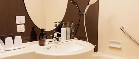 Ein Badezimmer mit weißem Waschbecken, einem Spiegel, einer Dusche und Pflegeprodukten.