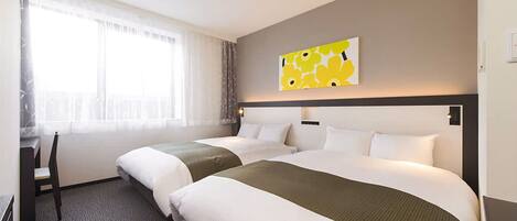 Quarto de hotel com duas camas, uma janela grande com cortinas finas, um quadro na parede e uma cadeira perto da janela.