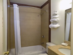 A bathroom with a shower, toilet, and sink.
