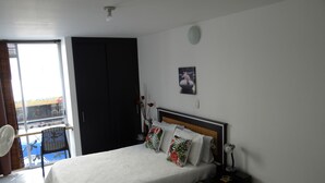 Une chambre à coucher avec un lit, une table de chevet, une chaise, une fenêtre et une porte.