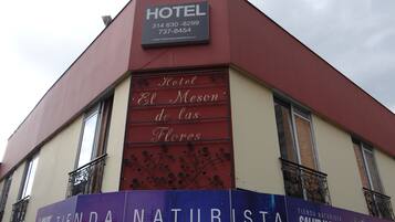 Un hôtel appelé « Hotel El Meson de las Flores », avec les numéros de téléphone et l’adresse du site web.
