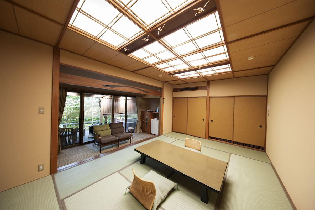 A traditional Japanese room with tatami flooring, a low table, and sliding doors.