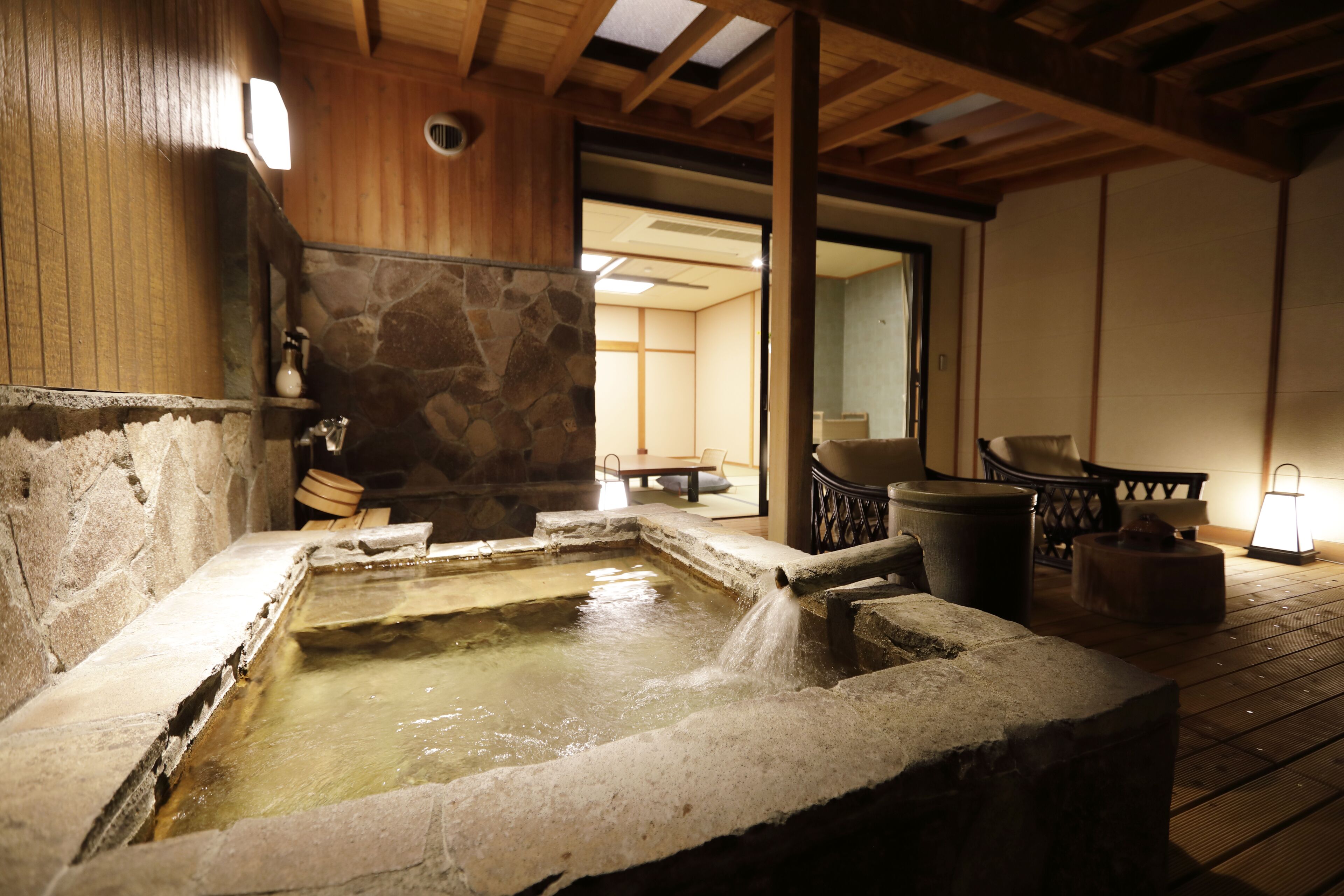 Un bain thermal en pierre, avec un plafond en bois et des murs en pierre.