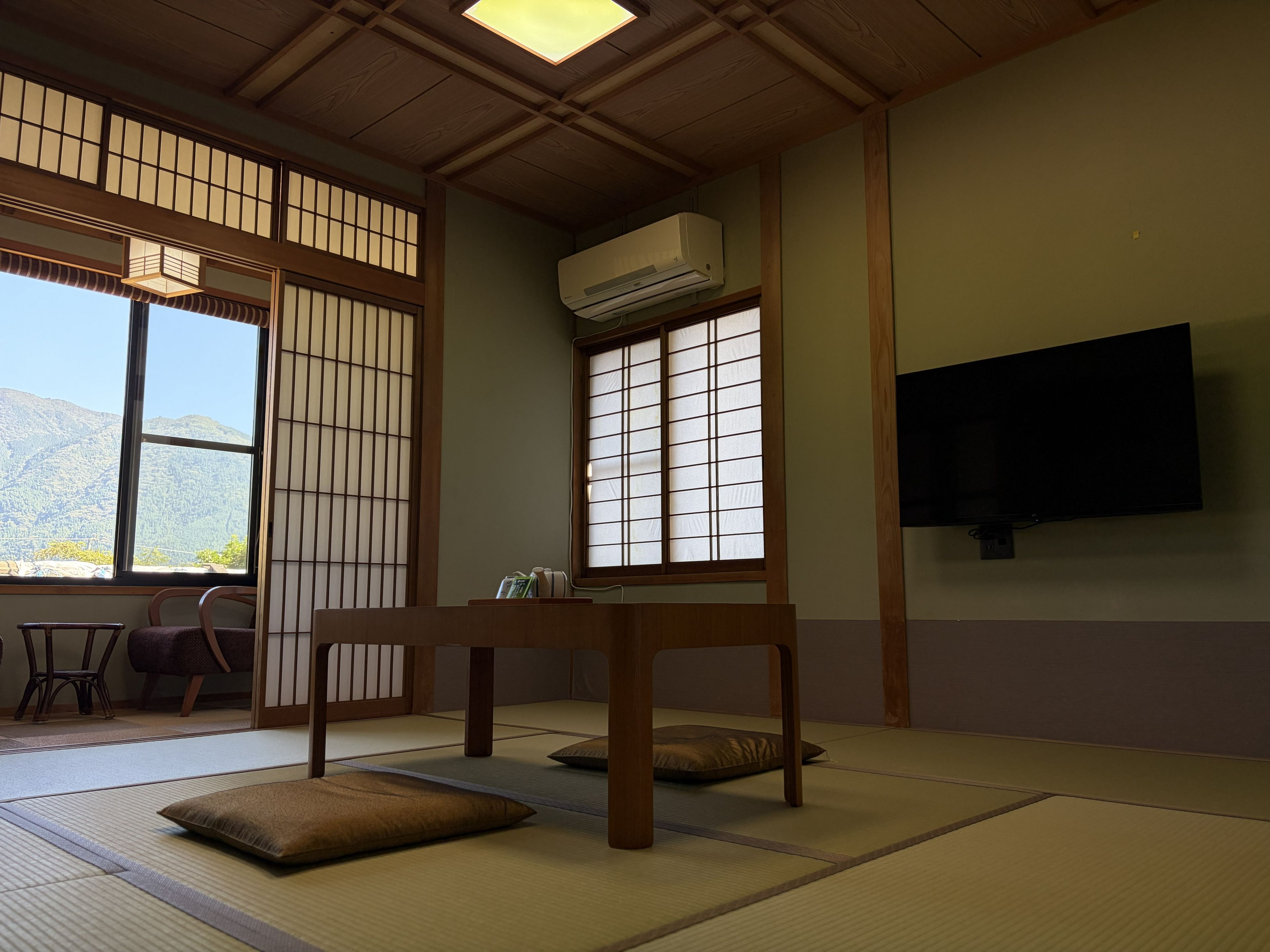 A traditional Japanese room with tatami flooring, a low wooden table, and sliding shoji doors.