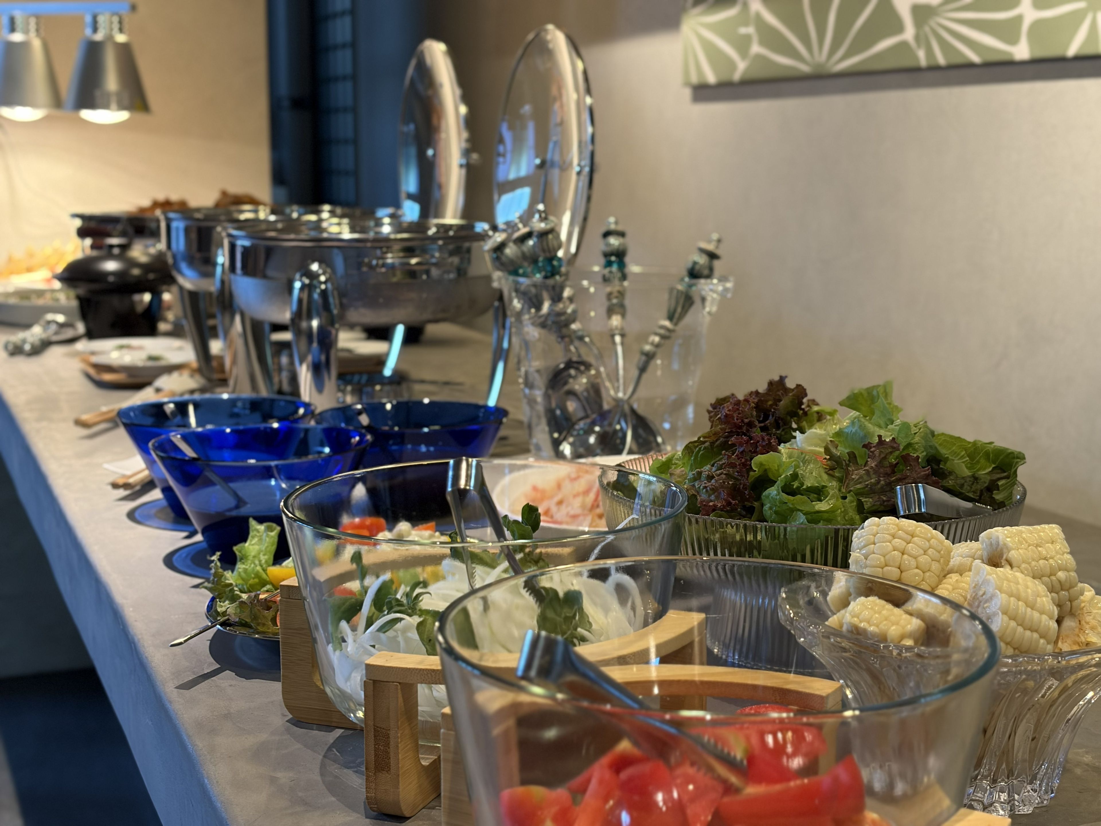 Un bufé con diversos alimentos y utensilios para servir.