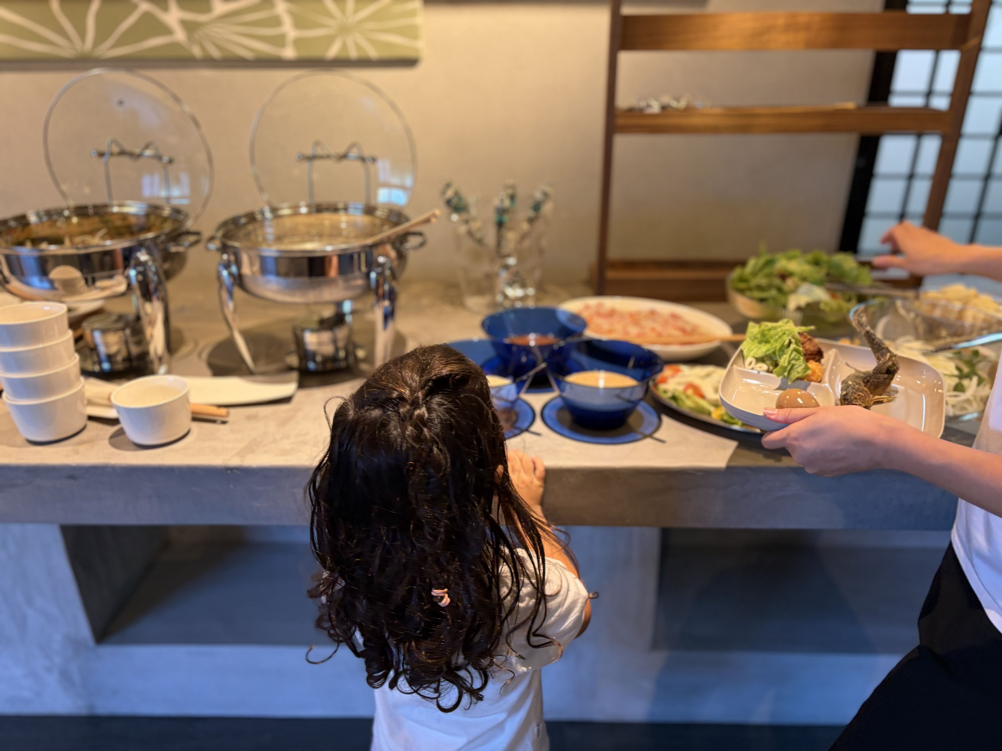 A buffet setup with various dishes and serving utensils.