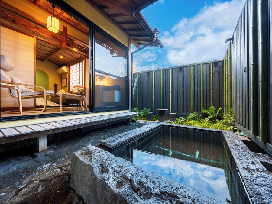 Ein modernes Spa mit einem von Glas umschlossenen Entspannungsbereich, einer Steinstarre und einem Bambuszaun.