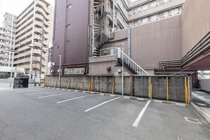Uma área de estacionamento com barreira de concreto e escadas que levam a um edifício.