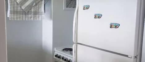 A compact kitchen with a microwave, stove, and refrigerator.