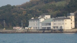 Un edificio costiero con diversi piani, un tetto piatto e vista sul lungomare.