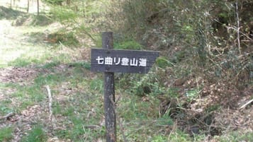 A signpost in a wooded area with Japanese text.