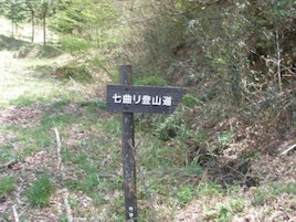 Un cartel en un área boscosa con texto en japonés.