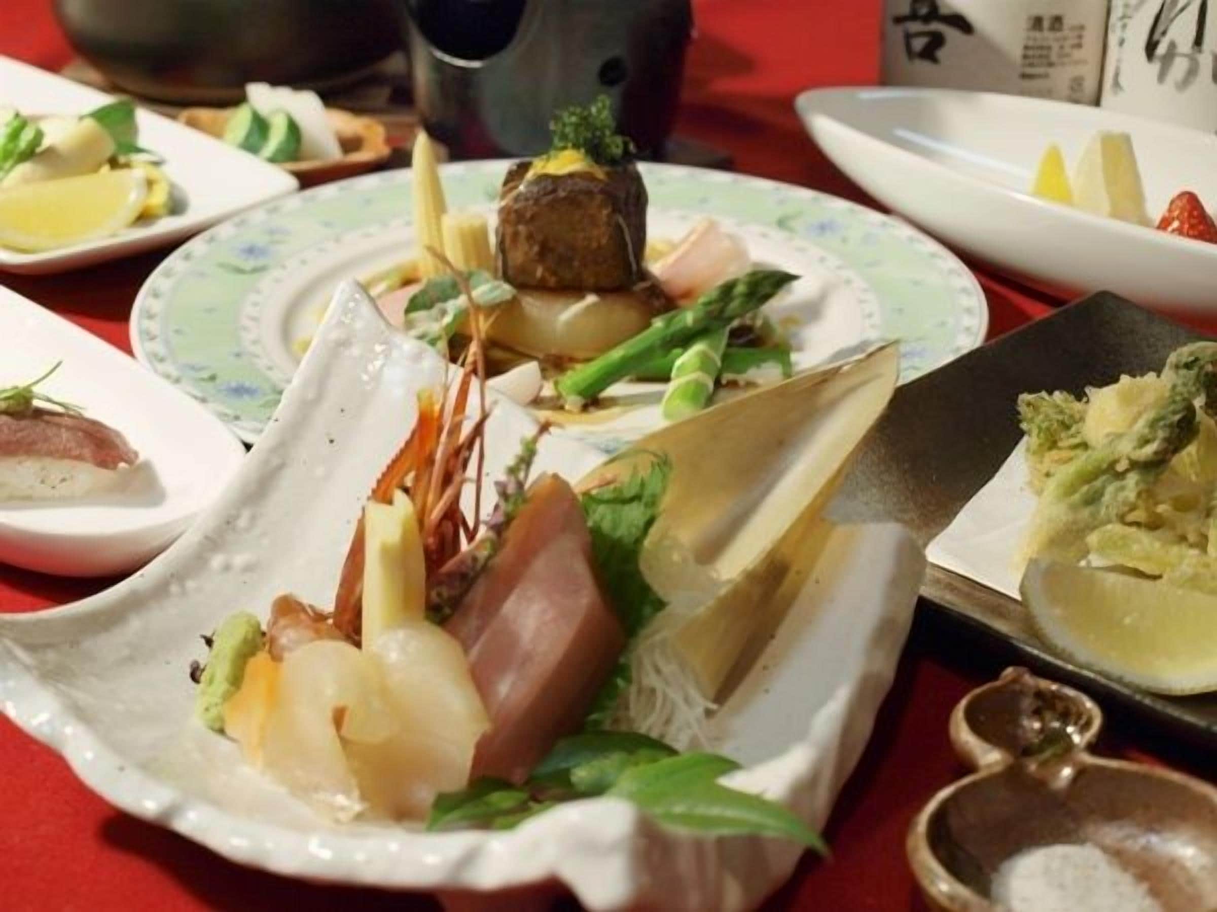 A table with various dishes, including seafood and vegetables, arranged on plates.