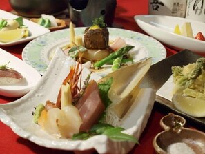 A table with various dishes, including seafood and vegetables, arranged on plates. - Takimikan (Daigo)