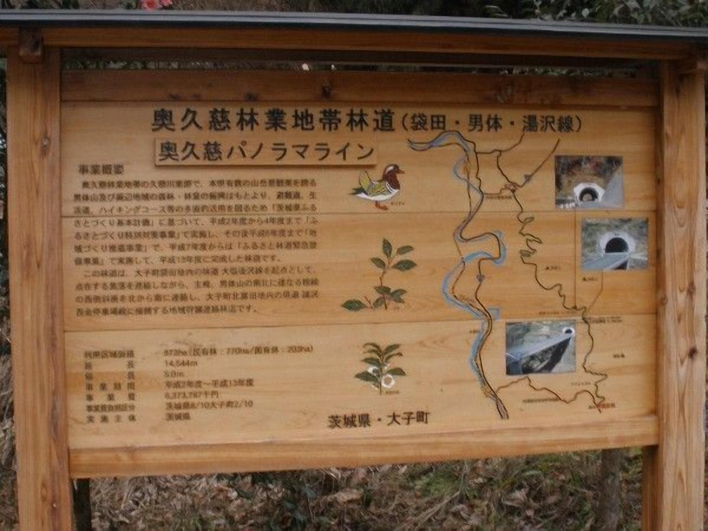 A wooden signboard with text and illustrations, likely providing information about a local area or landmark.