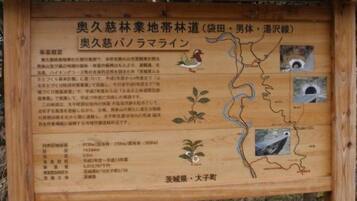 A wooden signboard with text and illustrations, likely providing information about a local area or landmark.