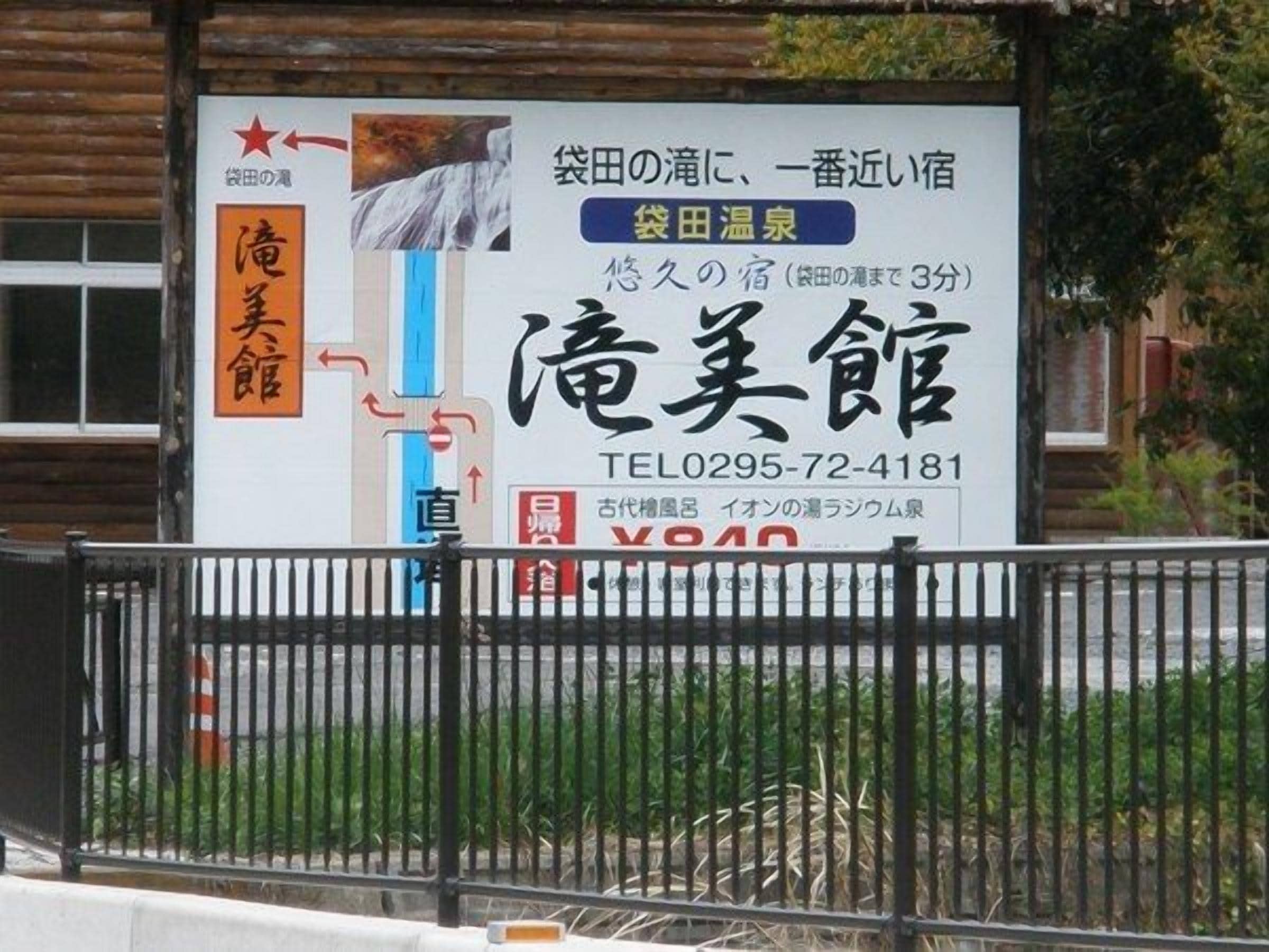 A hotel sign with contact information and a directional arrow.