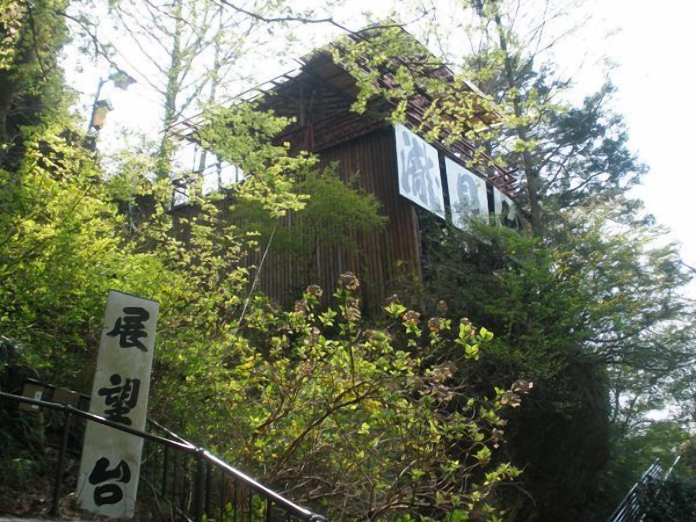 A traditional wooden building with signage, surrounded by lush greenery.