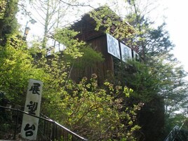 A traditional wooden building with signage, surrounded by lush greenery.