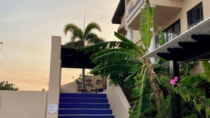 Un bâtiment doté d’un escalier menant à un espace couvert avec des sièges en plein air.