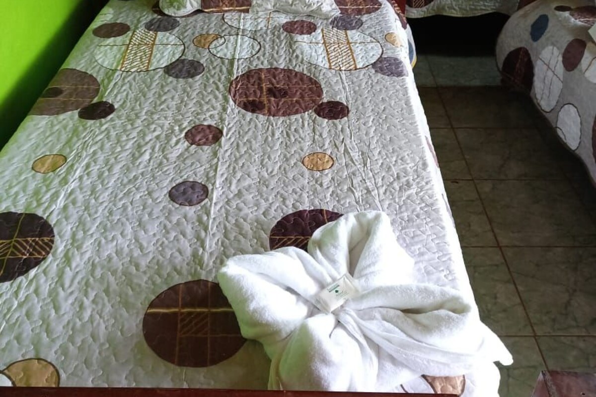 A room with two wooden beds, each with a quilted bedspread featuring circular patterns.